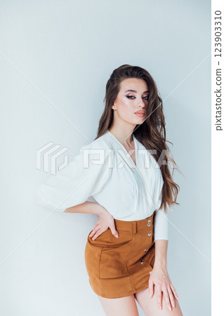 Beautiful slender woman smiling in white blouse and beige skirt Beautiful slender woman smiling in white blouse and beige skirt 123903310