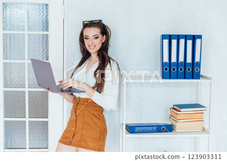 woman smiling with laptop in office negotiation online 123903311