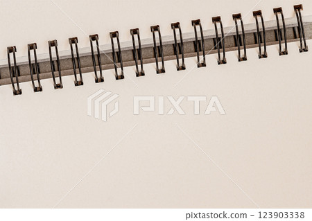 Minimalist spiral notebook with blank pages and metal binding. Clean and elegant background for business, education, stationery designs Minimalist spiral notebook with blank pages and metal binding. Clean and elegant background for business, education, stationery designs 123903338