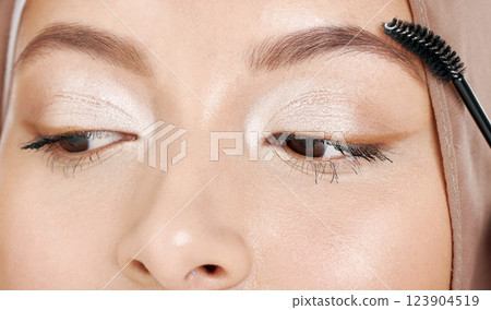 Beauty, muslim and makeup with eyebrow cosmetic tool for conservative glamour, style or elegance. Elegant eyeshadow look of islamic girl with hijab styling face with cosmetics brush close up. Beauty, muslim and makeup with eyebrow cosmetic tool for conservative glamour, style or elegance. Elegant eyeshadow look of islamic girl with hijab styling face with cosmetics brush close up. 123904519