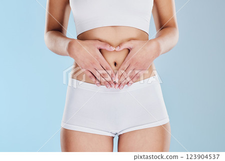 Healthy stomach, heart and woman hands, wellness and gut health, body contouring and diet on studio blue background. Fitness model belly love, digestion and skincare, laser liposuction and abdomen 123904537