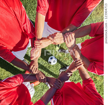 Soccer, hands and team sport with support before match, game or training with ball in circle group of men. Top of football field, pitch and grass with people showing trust, motivation and teamwork 123904713