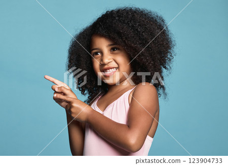 Advertising, hand and child with smile, happy and finger for blue mockup studio background. Face of a young African girl in happiness while pointing to show attention to marketing and mock up space Advertising, hand and child with smile, happy and finger for blue mockup studio background. Face of a young African girl in happiness while pointing to show attention to marketing and mock up space 123904733