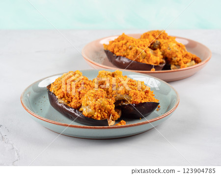 Baked eggplants stuffed with corn couscous with chickpea sauce Baked eggplants stuffed with corn couscous with chickpea sauce 123904785