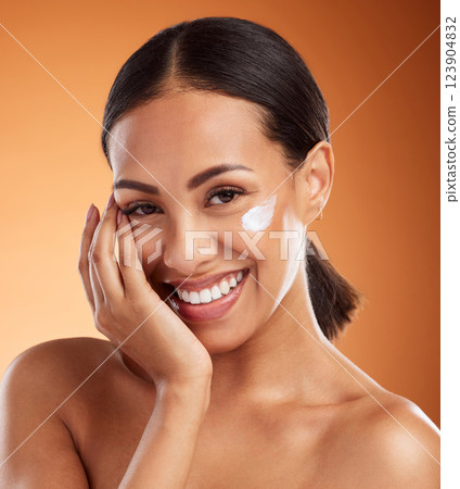 Skincare, beauty cream and woman with cream on face product against a orange mockup studio background. Happy and smile model with cosmetics for skin, body wellness and cosmetology or dermatology Skincare, beauty cream and woman with cream on face product against a orange mockup studio background. Happy and smile model with cosmetics for skin, body wellness and cosmetology or dermatology 123904832