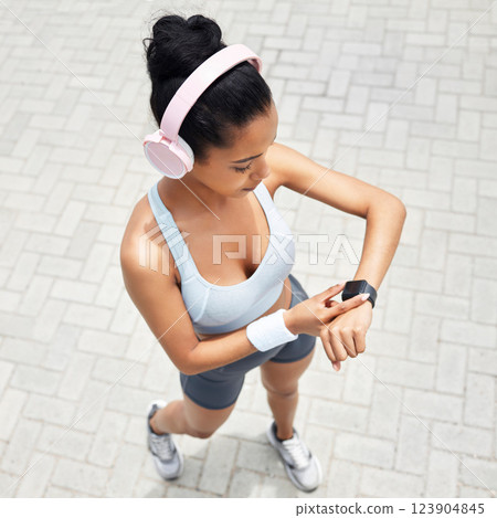 Fitness, woman and watch of runner time monitoring health, performance and distance above outdoors. Active female checking wrist app after a run outside listening to music for training and exercise 123904845