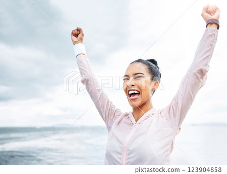 Happy woman, beach fitness success and achievement, freedom and motivation goals, energy and wellness on clouds sky background. Excited sports female winner, fist arms up celebration and inspiration Happy woman, beach fitness success and achievement, freedom and motivation goals, energy and wellness on clouds sky background. Excited sports female winner, fist arms up celebration and inspiration 123904858