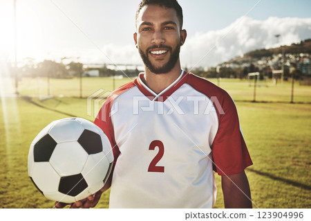 Portrait, soccer player and man with a soccer ball at a field, happy, smile and excited about sports goal at soccer field. Football player, fitness and guy at a football field for training workout 123904996