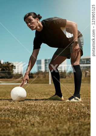 Man, placing and soccer ball with hand on field for kick, penalty or goal in game, training or match. Sport, football and grass in summer for exercise, fitness and workout in sports for wellness 123905125