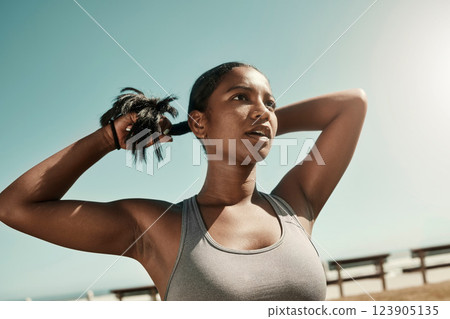 Woman tying her hair before an outdoor workout for fitness, health and wellness in nature. Training, sports and healthy girl athlete from Mexico preparing for a run or cardio exercise in a field. Woman tying her hair before an outdoor workout for fitness, health and wellness in nature. Training, sports and healthy girl athlete from Mexico preparing for a run or cardio exercise in a field. 123905135