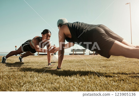 Fitness, couple and support in plank and balance training during fitness, workout and exercise on a field. Sport, strong and fit athletes helping with motivation wellness challenge on grass field Fitness, couple and support in plank and balance training during fitness, workout and exercise on a field. Sport, strong and fit athletes helping with motivation wellness challenge on grass field 123905136