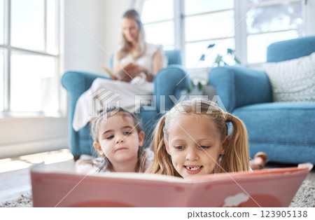 Book, kids and family with a girl and sister reading while lying on the living room floor of their home together. 123905138