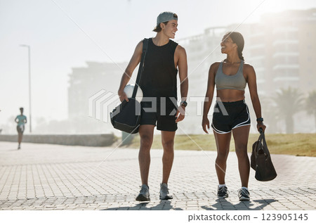 Sports, personal trainer and woman in fitness walking with a soccer ball for cardio exercise, workout and training session. Smile, wellness and happy couple enjoy a healthy city lifestyle in summer 123905145