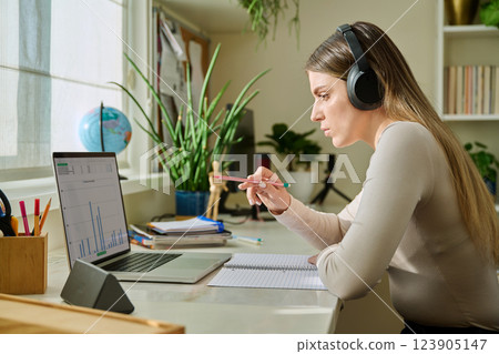 Young woman using typing working studying on laptop, side view of computer screen 123905147