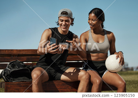 Sports friends, phone and relax while sitting in a park together, bond and laughing at social media post before morning cardio. Fitness, couple and online entertainment on park bench after training 123905150
