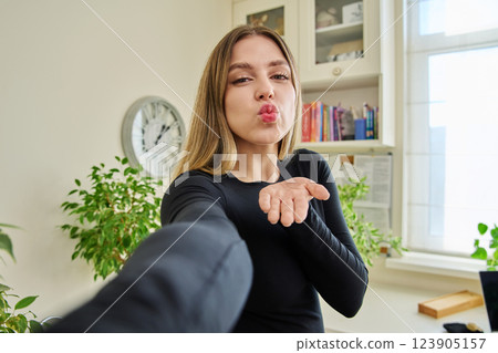 Close-up selfie portrait of young cheerful woman looking at web camera Close-up selfie portrait of young cheerful woman looking at web camera 123905157