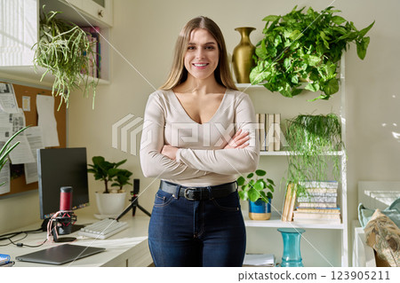 Portrait of young confident smiling woman in home interior 123905211