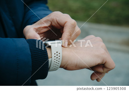 man activating his smartwatch outdoors man activating his smartwatch outdoors 123905308