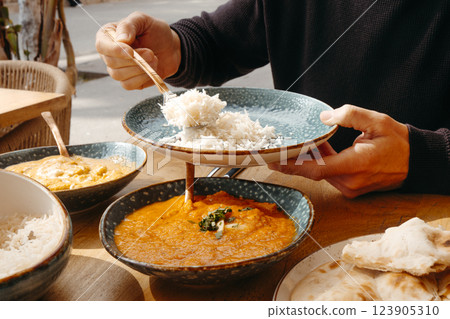man serving some basmati rice on a plate 123905310