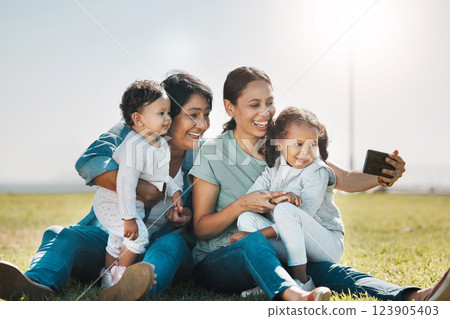 Phone, selfie and family with a woman, girl and sister taking a photograph while enjoying a summer picnic on a field of grass. Love, grandmother and generations with a mother posing for a picture 123905403