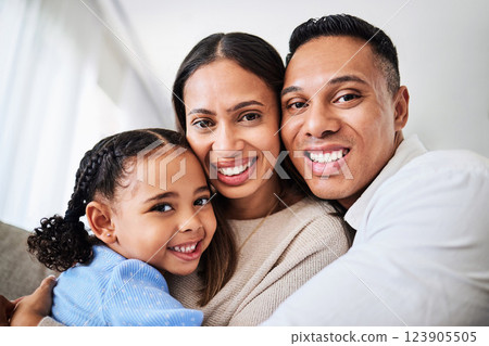 Family, happy and face portrait in living room home, smiling and bonding. Love, care and happy parents, child or girl hugging, embrace or spending quality time together in house with smile or support 123905505