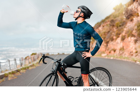 Cyclist, drinking water or fitness break on road in workout, training or exercise in competition race, health wellness. Sports man, bike athlete or thirsty cycling person on France countryside street Cyclist, drinking water or fitness break on road in workout, training or exercise in competition race, health wellness. Sports man, bike athlete or thirsty cycling person on France countryside street 123905644