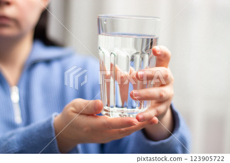 Close up image of woman holding glass of water. Concept of water balance. Long living. Healthy wellbeing. Close up image of woman holding glass of water. Concept of water balance. Long living. Healthy wellbeing. 123905722