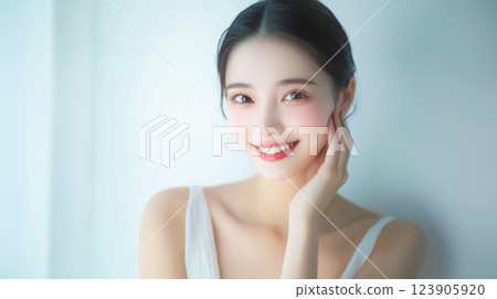 Beauty portrait of a young and pretty Asian female model with fair skin, smiling and posing with hand on cheek. Beauty portrait of a young and pretty Asian female model with fair skin, smiling and posing with hand on cheek. 123905920