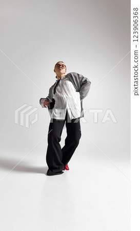 Full length photo of stylish professional, female model, with intense gaze, dancing, celebrating career development. Full length photo of stylish professional, female model, with intense gaze, dancing, celebrating career development. 123906368