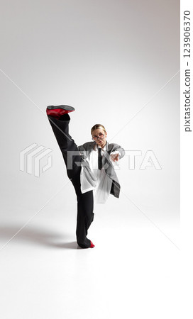 Expressive movement of young female professional, dressed oversized jacket, flowing in motion against white background. Expressive movement of young female professional, dressed oversized jacket, flowing in motion against white background. 123906370