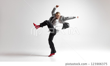 Energetic mid-air jump of confident woman in modern office outfit against white background, expressing creativity and freedom. Energetic mid-air jump of confident woman in modern office outfit against white background, expressing creativity and freedom. 123906375