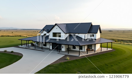 Modern farmhouse design overlooking expansive landscape during golden hour Modern farmhouse design overlooking expansive landscape during golden hour 123906779
