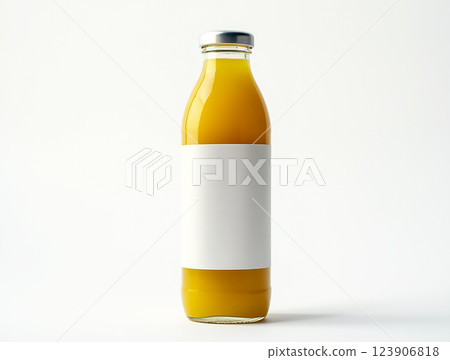 Clear glass bottle filled with bright yellow beverage on a plain white background 123906818