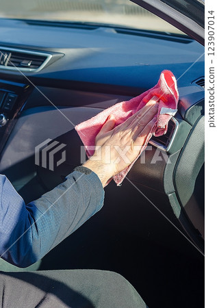 Hand wiping car dashboard with a microfibre cloth. High quality photo Hand wiping car dashboard with a microfibre cloth. High quality photo 123907014