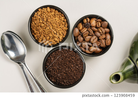 Different types of coffee. Ground coffee, instant coffee and roasted coffee beans in small bowls Different types of coffee. Ground coffee, instant coffee and roasted coffee beans in small bowls 123908459