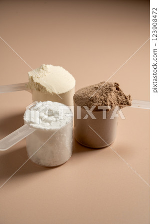 Chocolate, vanilla protein powder in scoops. Food supplement, fitness sport, health and nutrition. 123908472