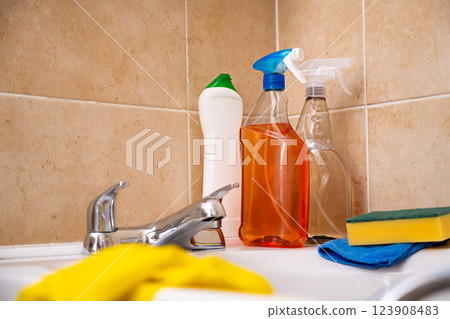 Spray detergents, cleaning bathroom tube and water tap, yellow gloves and fibber cloth 123908483