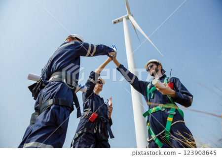 Successful teamwork engineer wind turbine worker safety uniform survey operational planning windmill field clean energy. Alternative technology protect environment reduce global warming problems. 123908645