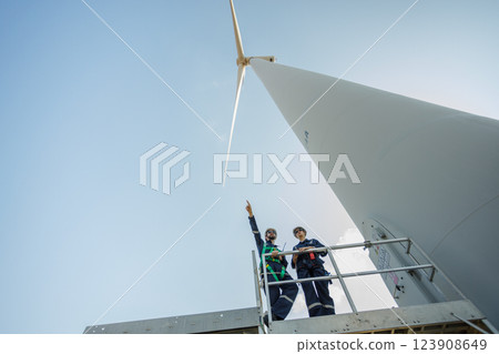Team engineer wind turbine worker safety uniform survey discuss operational planning windmill field clean energy. Alternative technology protect environment reduce global warming problems. Team engineer wind turbine worker safety uniform survey discuss operational planning windmill field clean energy. Alternative technology protect environment reduce global warming problems. 123908649