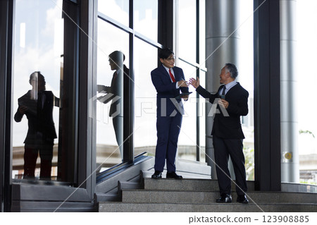 Senior businessperson is giving advice and coaching to new generation of young businessman. senior and young businessman brainstorming business development. Working together between two generations. 123908885