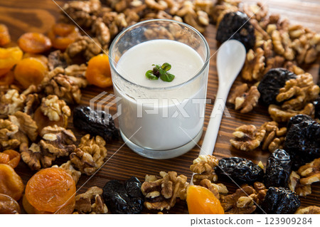 natural yogurt with nuts, dried apricots and prunes on a wooden table 123909284