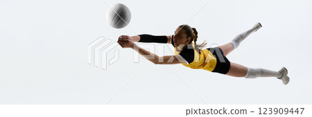 Young woman in yellow jersey and black shorts, volleyball player in motion, hitting ball isolated on white background 123909447
