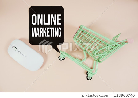 Online Marketing text on speech bubble with optical mouse and trolley shopping cart on pink background Online Marketing text on speech bubble with optical mouse and trolley shopping cart on pink background 123909740