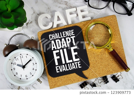 CAFE - Challenge, Adapt, File, Evaluate acronym with alarm clock and magnifying glass, business concept background 123909773