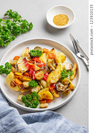 Baked vegetables potatoes, cabbage, pepper and onion in a plate on a light background Baked vegetables potatoes, cabbage, pepper and onion in a plate on a light background 123910135