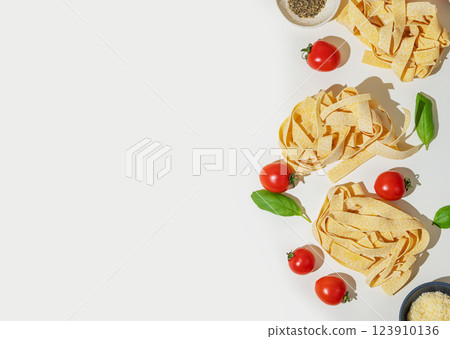 Flat-lay of fresh pasta with tomatoes and basil on white background. 123910136