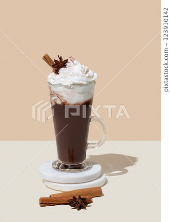 Hot chocolate with whipped cream, cinnamon and spices in a tall glass on a beige background Hot chocolate with whipped cream, cinnamon and spices in a tall glass on a beige background 123910142