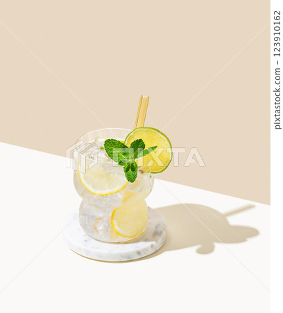 Fresh mocktail mojito with lemon, lime, mint and ice. Citrus lemonade on a white beige  background 123910162