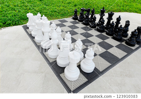 Game board with outdoor giant chess set in the garden. Game board with outdoor giant chess set in the garden. 123910383