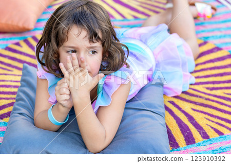 Adorable toddler girl is on the bright mat outdoors in the garden. Adorable toddler girl is on the bright mat outdoors in the garden. 123910392